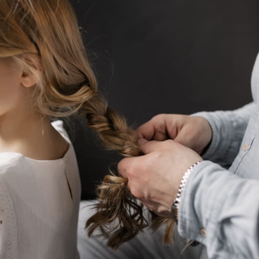Trenzando el cabello de una niña en el salón