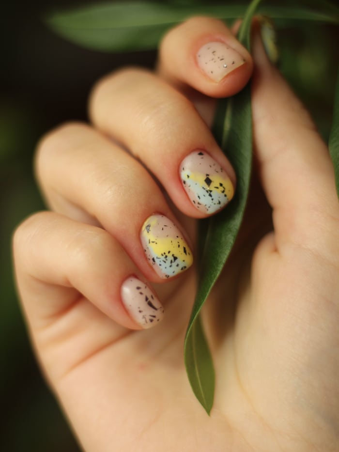 Nail art con flores prensadas sobre uñas naturales