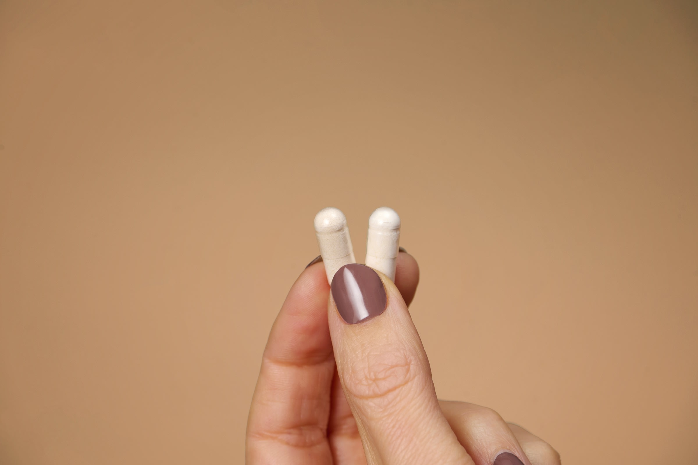 Twee kleine Balance capsules in de hand — het dagelijkse ritueel