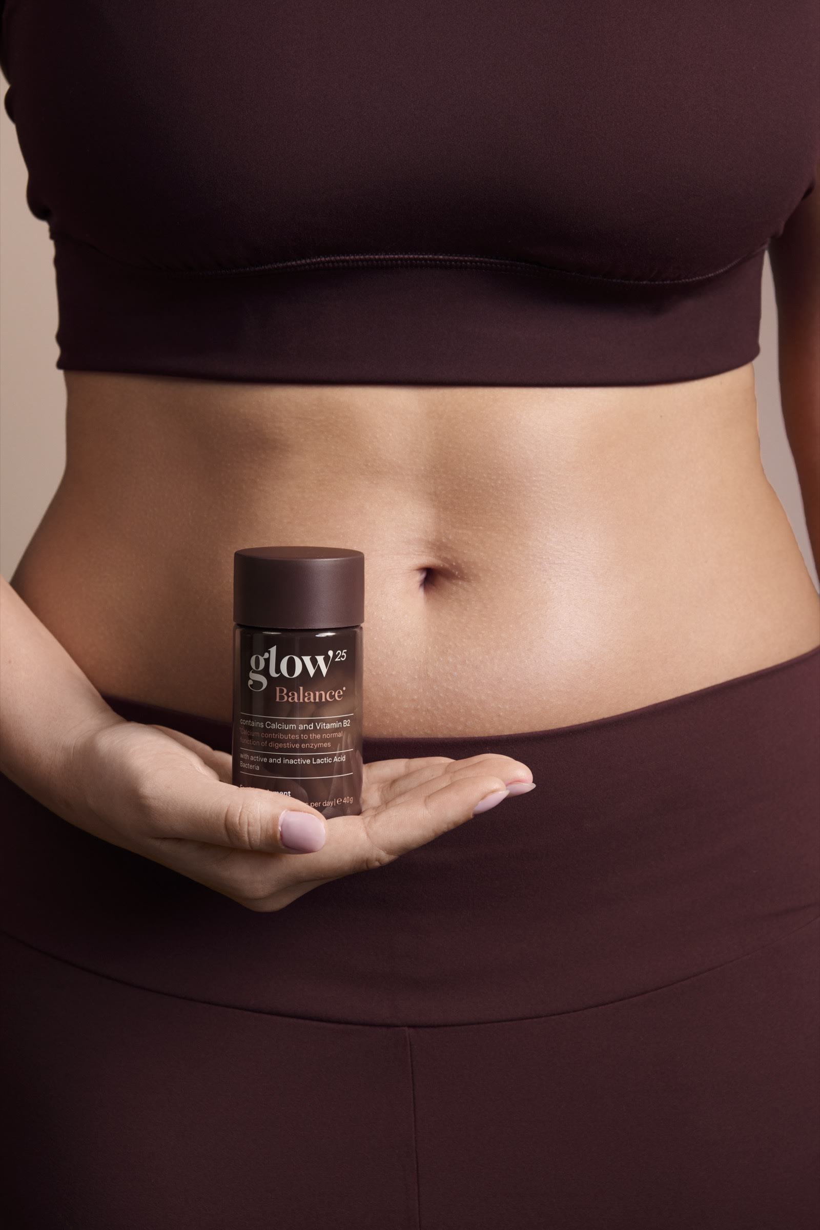 Close-up van het middel van een vrouw die de Glow25 Balance pot tegen haar buik houdt