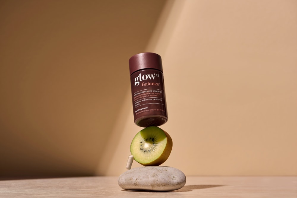 Un pot Glow25 Balance posé sur une tranche de kiwi doré