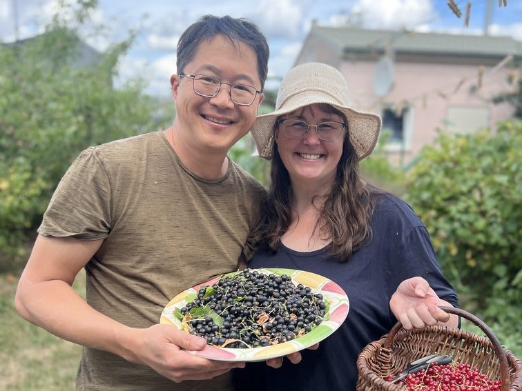 Happy couple holding plate of fresh black beans and basket of red beans