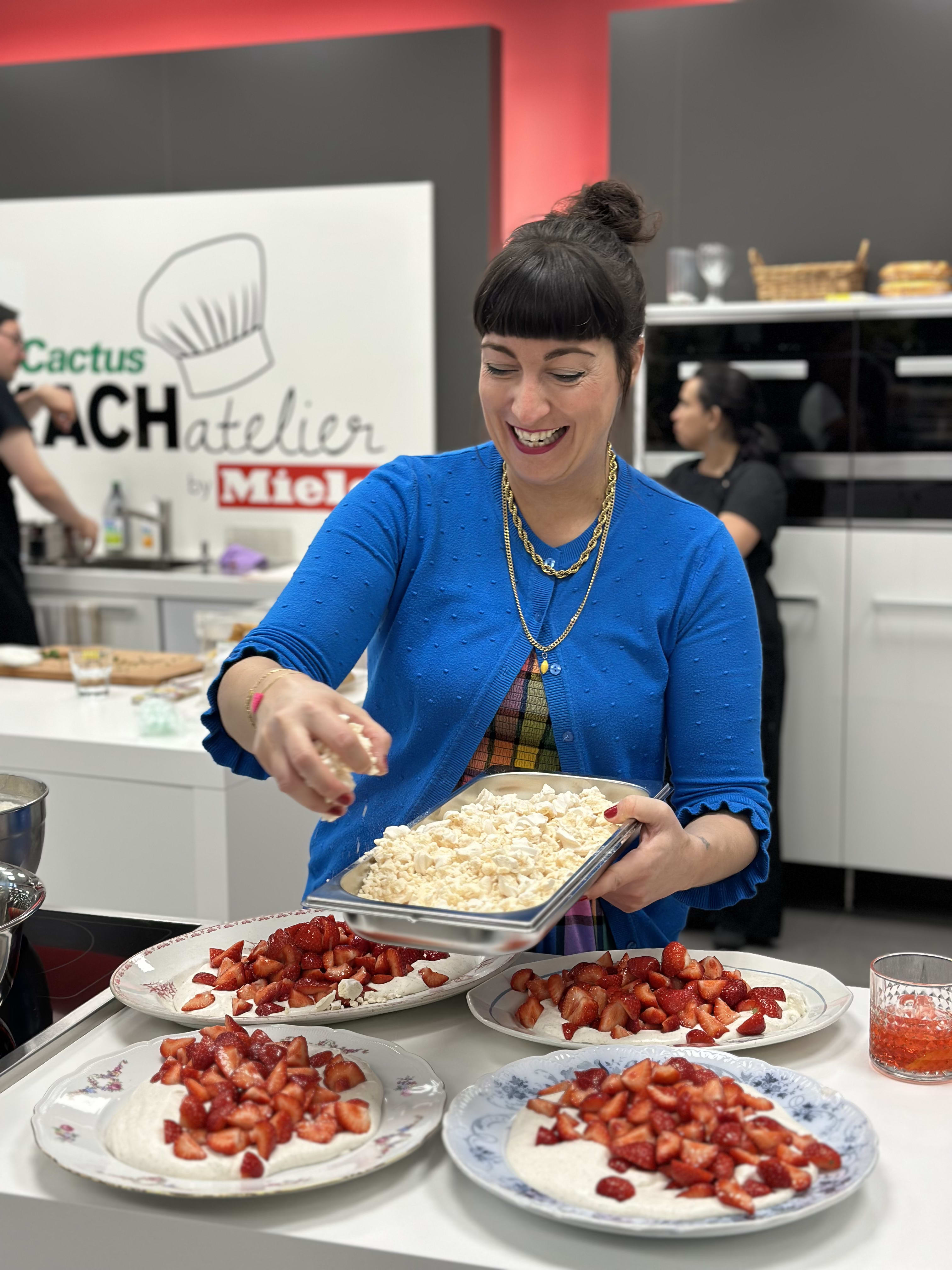 Woman in blue shirt sprinkling toppings on strawberry desserts at Cactus Club cooking demonstration