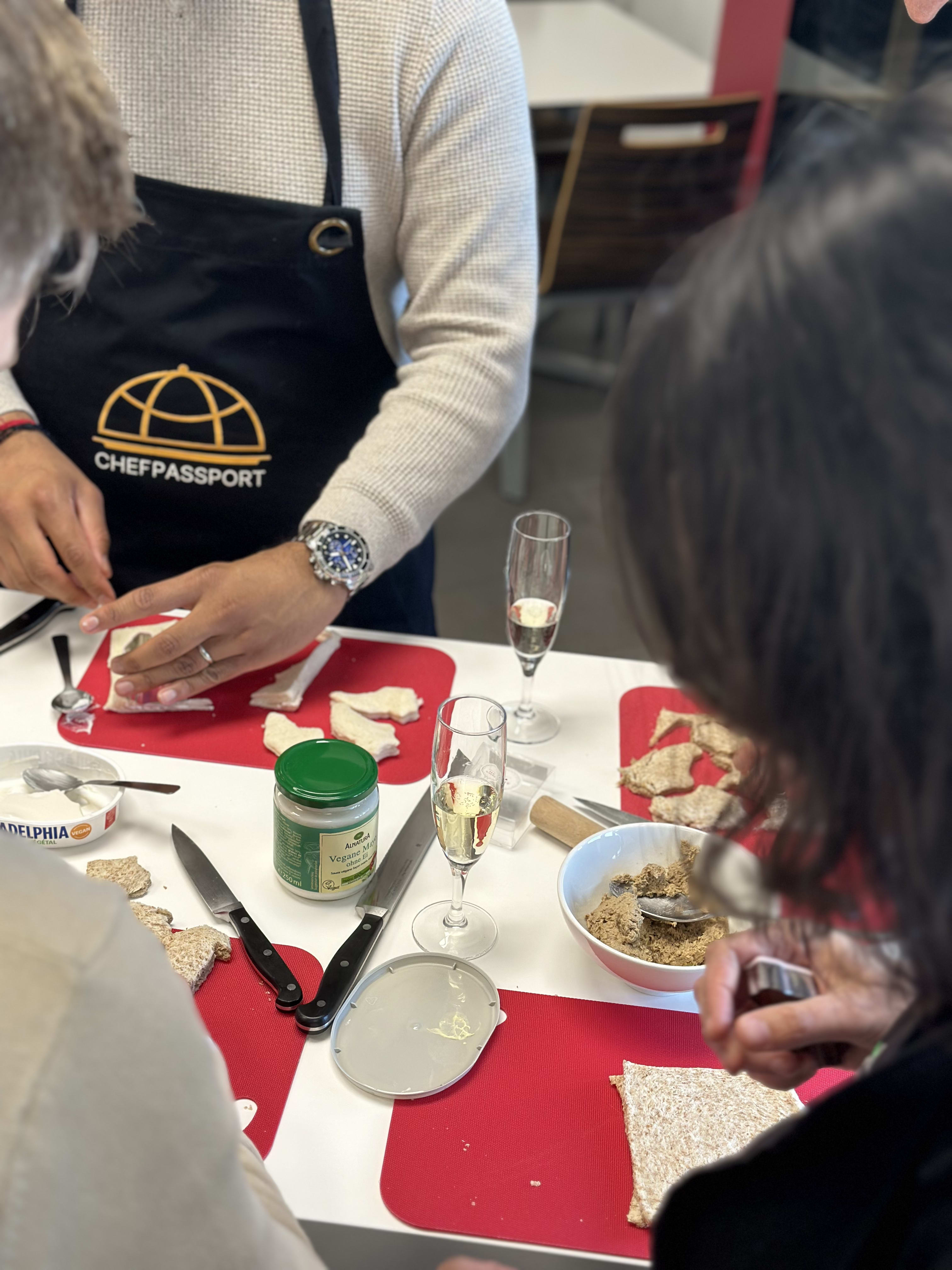 People making holiday appetizers with crackers and spreads at a Chef Passport cooking class