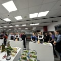 Diverse cooking class participants wearing aprons smiling at tables in bright Luxembourg venue