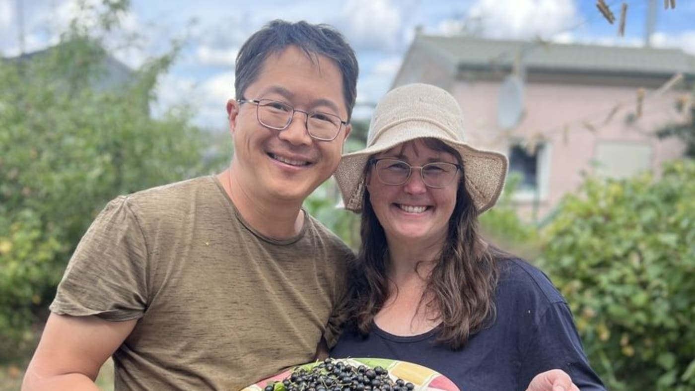Happy couple holding plate of fresh black beans and basket of red beans