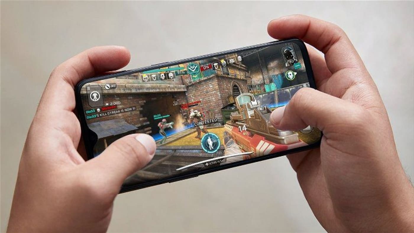 Hands holding a phone playing a game — quick games to play with colleagues