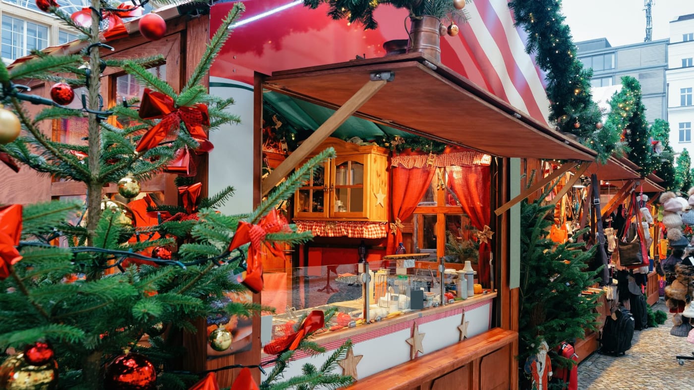 Christmas market wooden stall decorated with festive trees and red ornaments