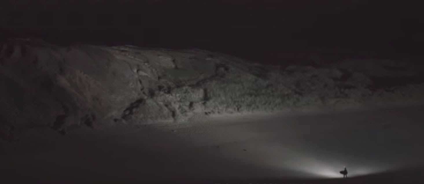 nightsurfer lighting a hill after a session