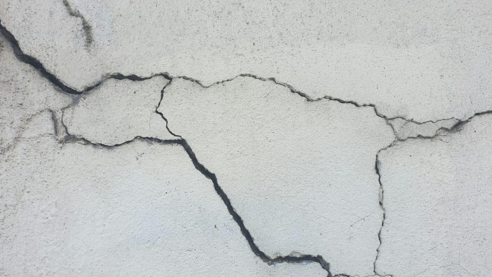Structural crack and spalling concrete on a Miami building wall before repair