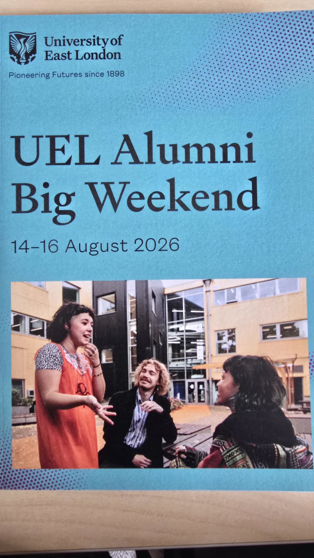 The printed UEL Alumni Big Weekend 2026 programme booklet, dated 14 to 16 August, with a cover photo of three alumni chatting on campus.