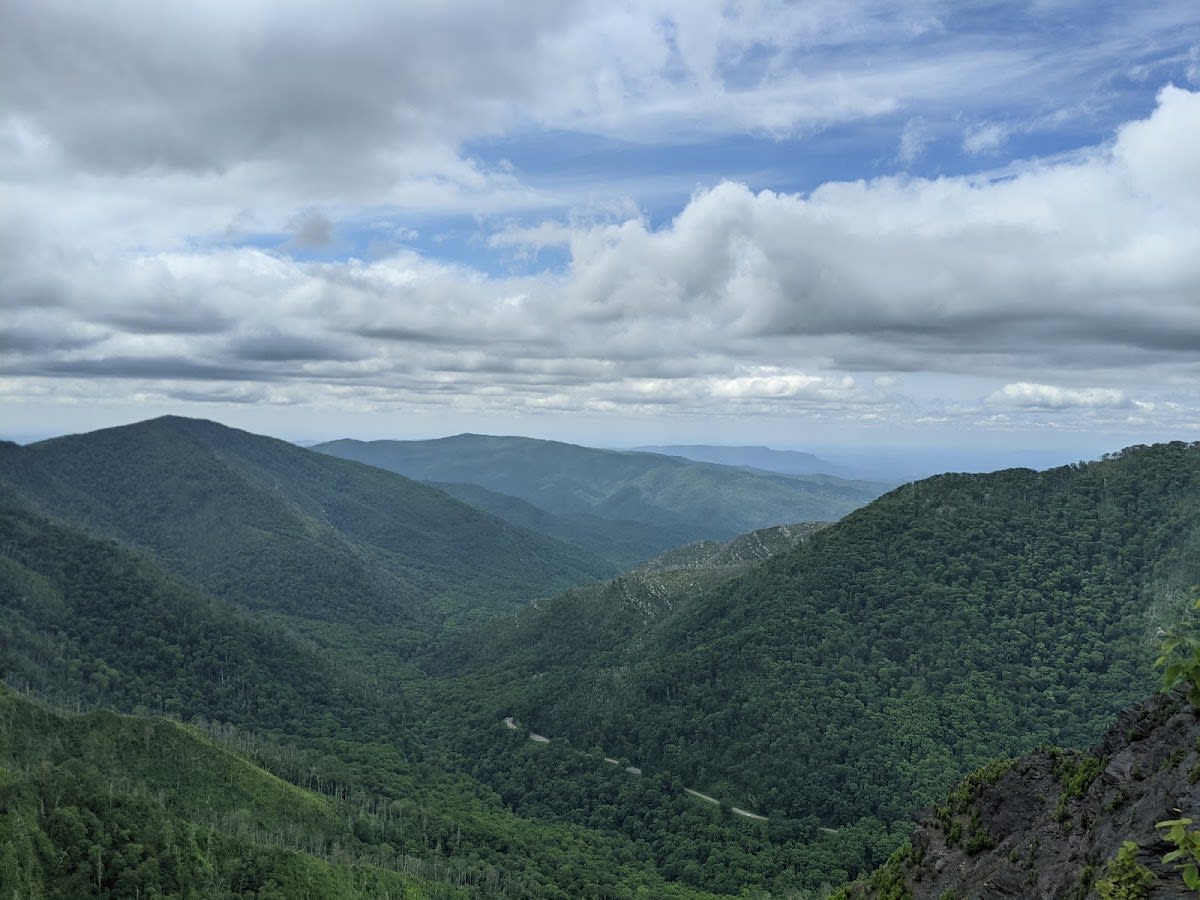 A hiker enjoying the panoramic view from the Chimney Tops trail observation deck in the Great Smoky Mountains.