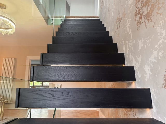 Floating · charcoal oak, stone wall — staircase or glass install by CAworks