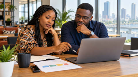 Two Nigerian professionals reviewing a business development plan together in a Lagos coworking space
