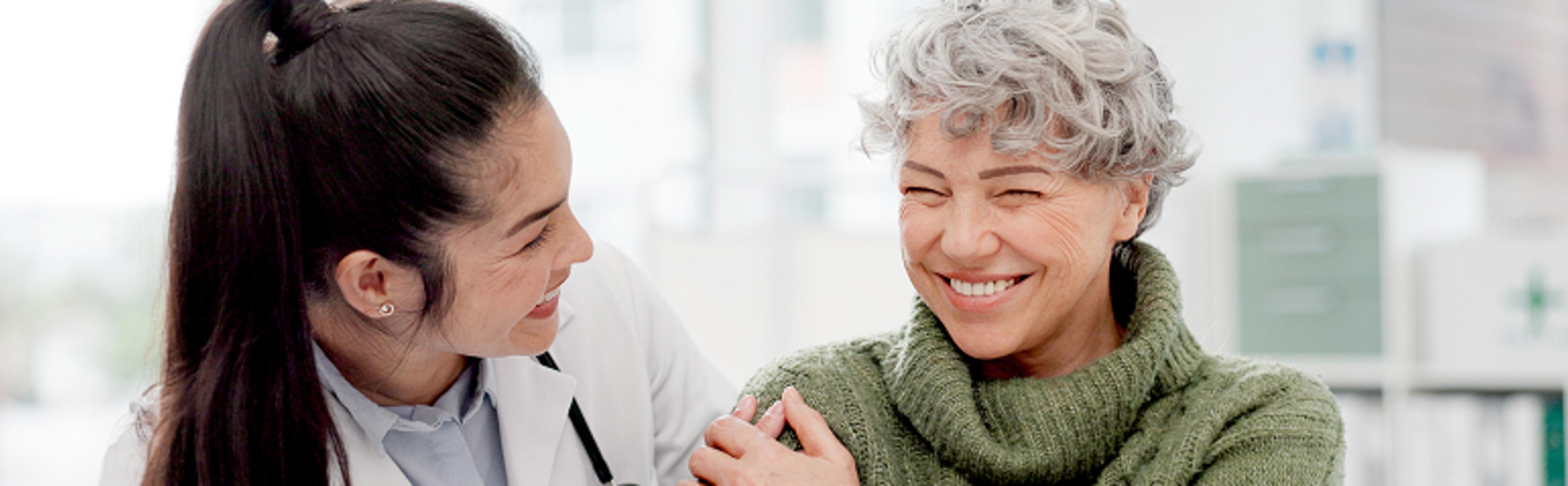 A healthcare professional comforts a patient as they both smile