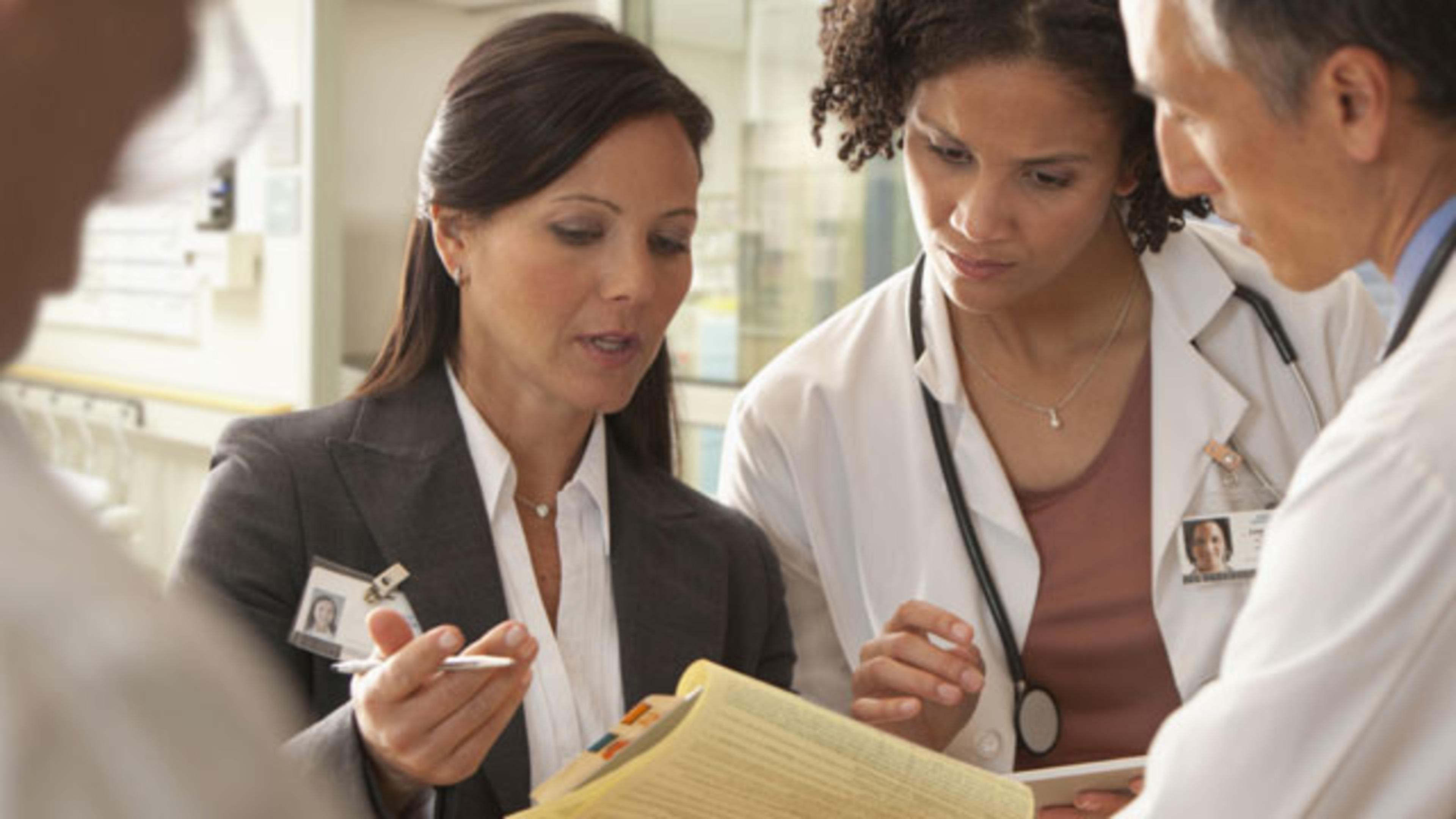 Group of medical professionals discussing and reviewing notes in a hospital setting