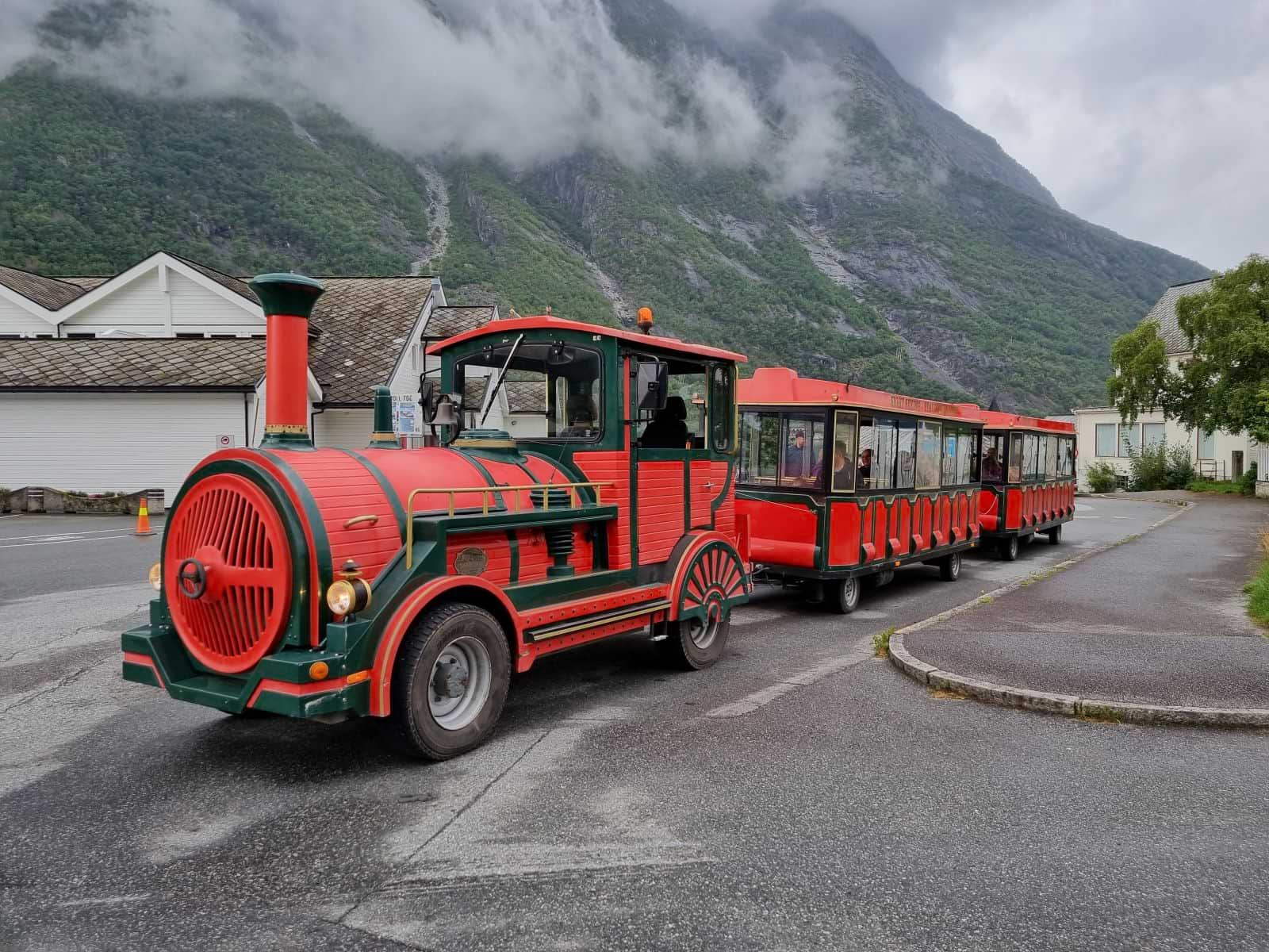 Red and green mini train on wheels (the Trolltrain) parked in Eidfjord.