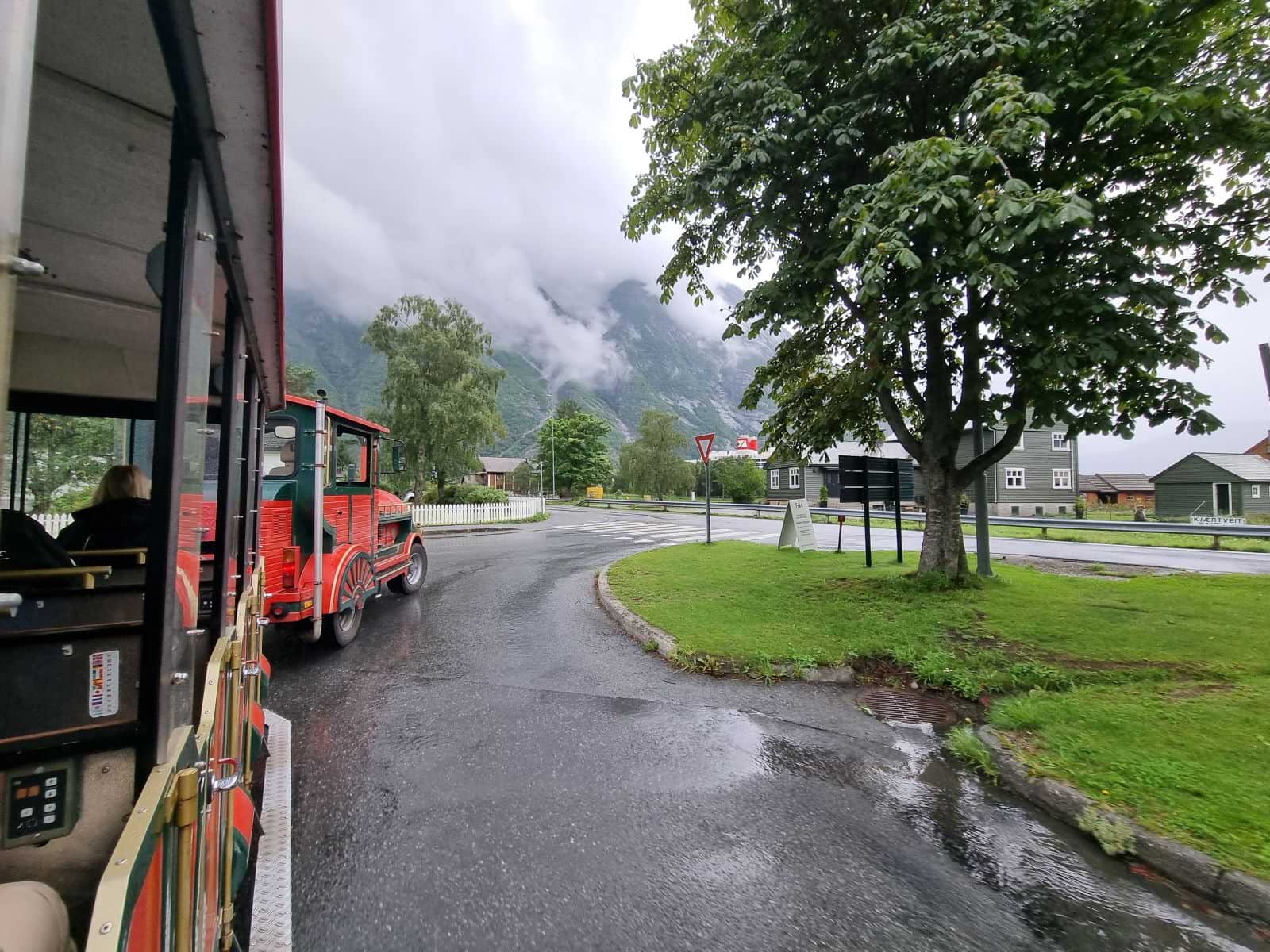 Rot-grüner Minizug auf Rädern (der Trollzug), der durch Eidfjord fährt.