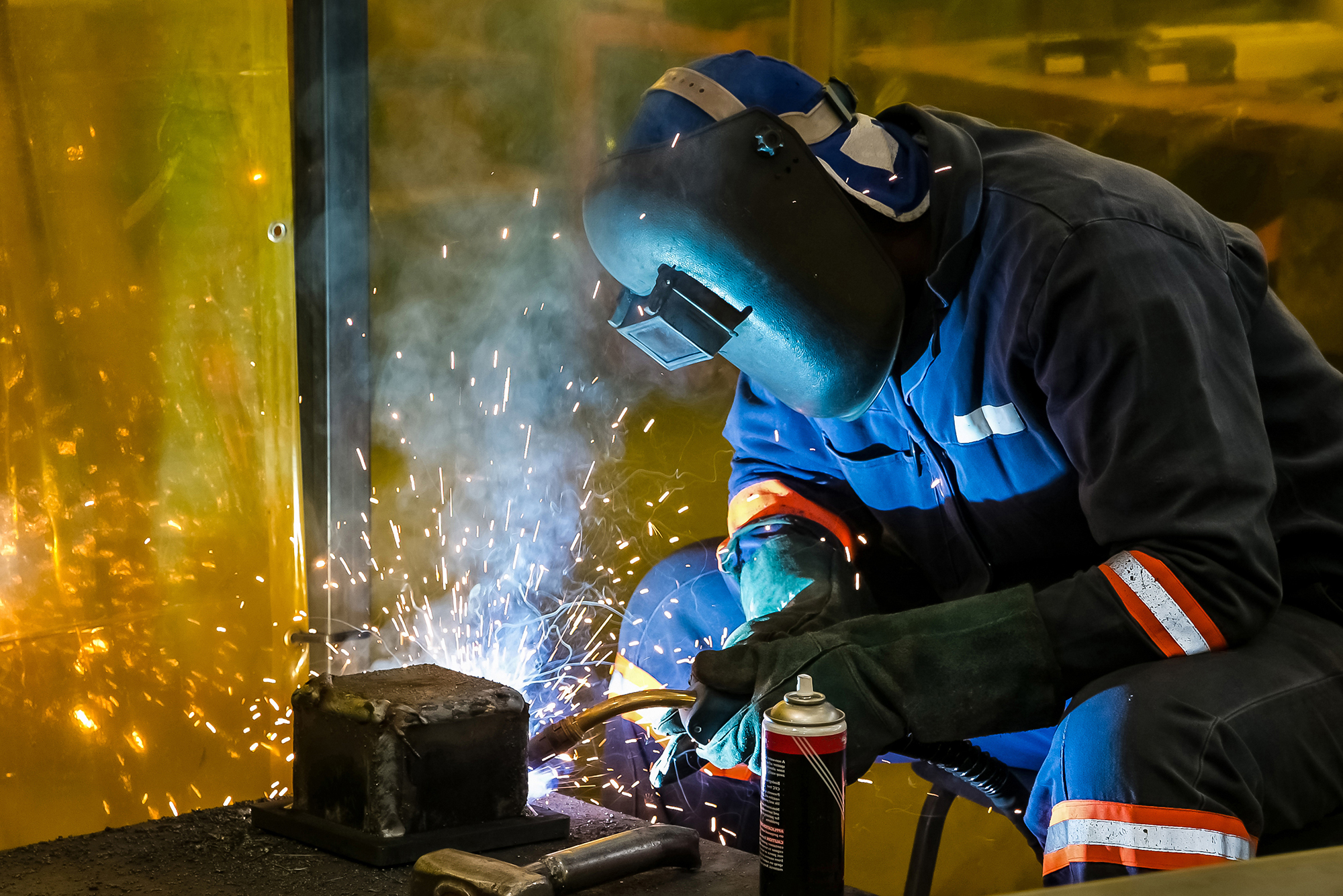 A welder joining a steel frame in the workshop