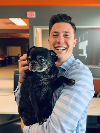 OptimumHQ intern Jacob Swanson and office mascot Cooper the pug