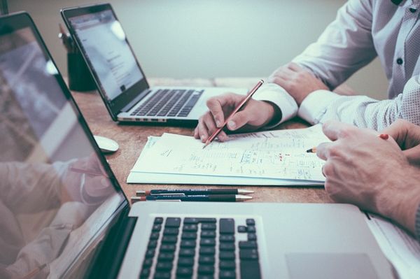 employees researching trade show attendance on laptops