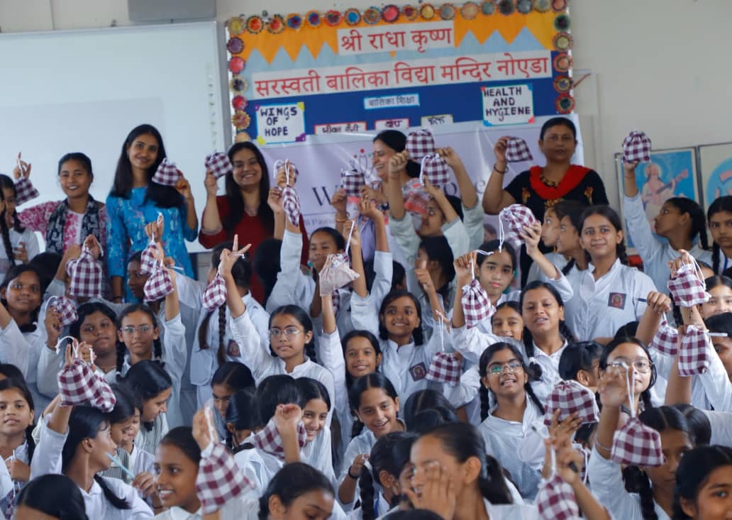 Schoolgirls holding hygiene kits at a Wings of Hope health and hygiene session