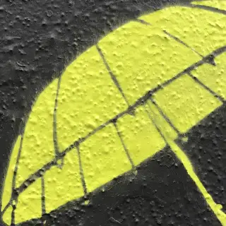 En stencil af en paraply på asfalt