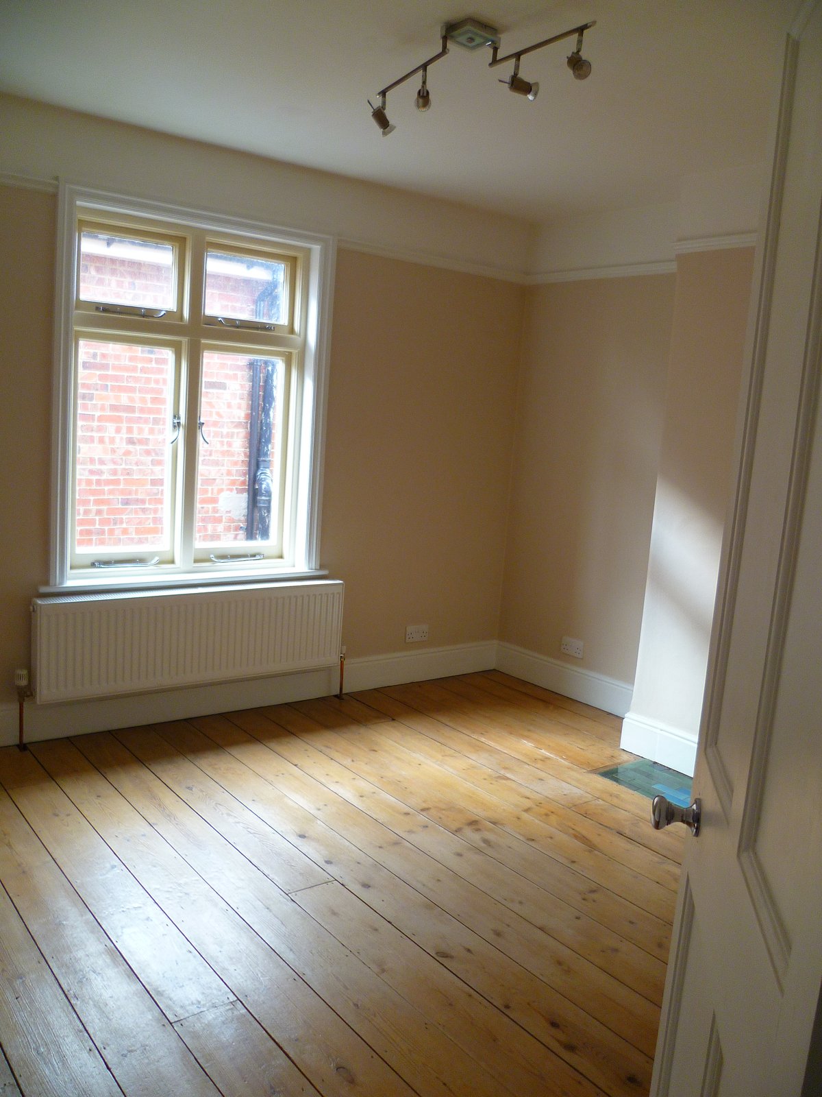 An image showing restoration work for the back bedroom including floor sanding and refinishing, plastering, and painting and decorating
