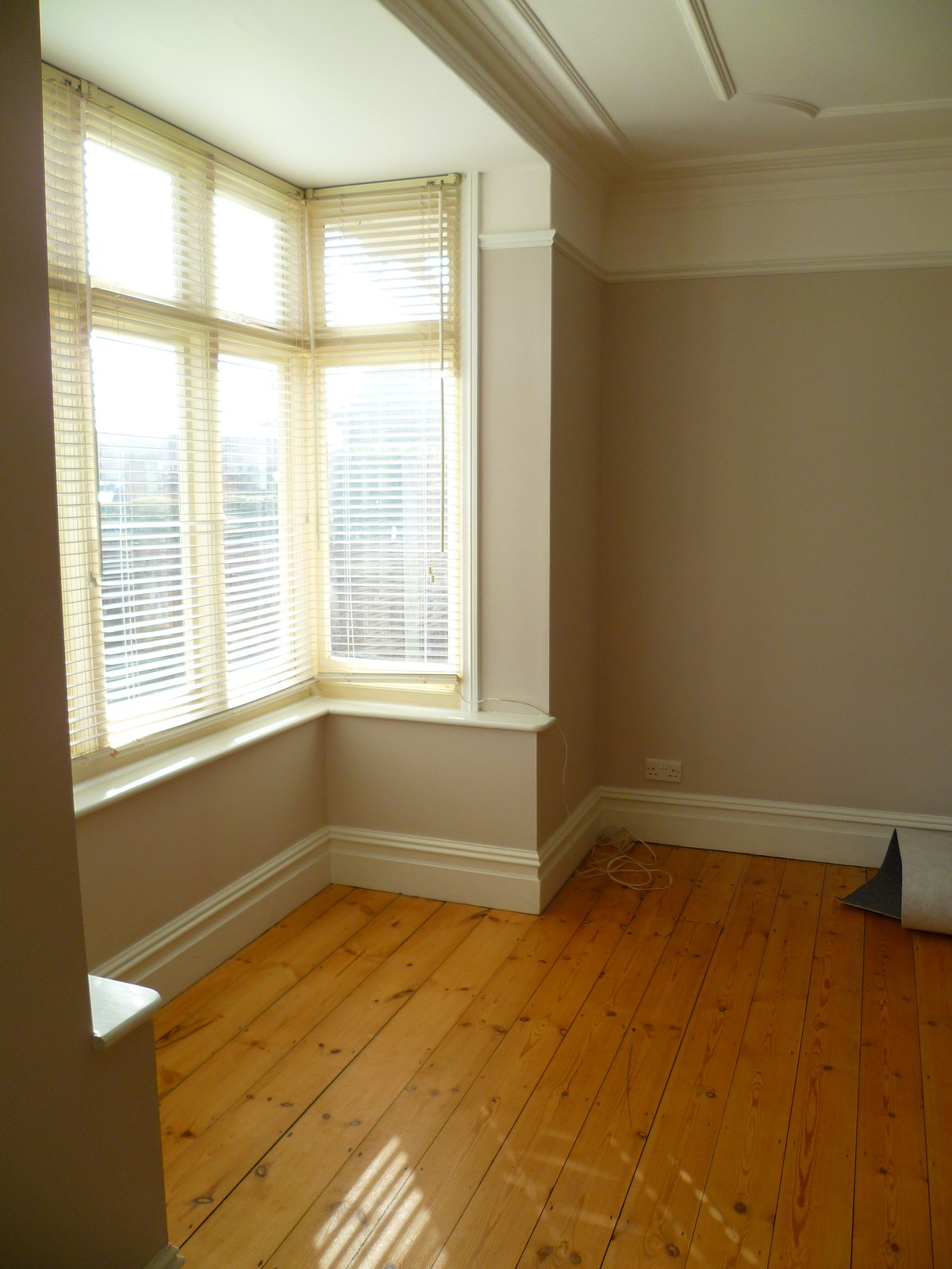 An image showing restoration work for the back bedroom including floor sanding and refinishing, plastering, and painting and decorating