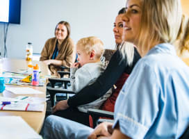 People around a table with a baby, all smiling