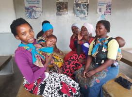 Five women with children waiting for their turn to vaccinate