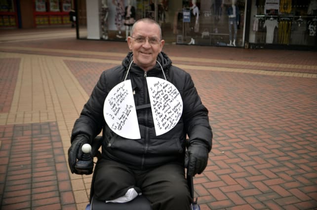 Image of man in wheelchair with two semi-circular boards with writing about breathlessness.