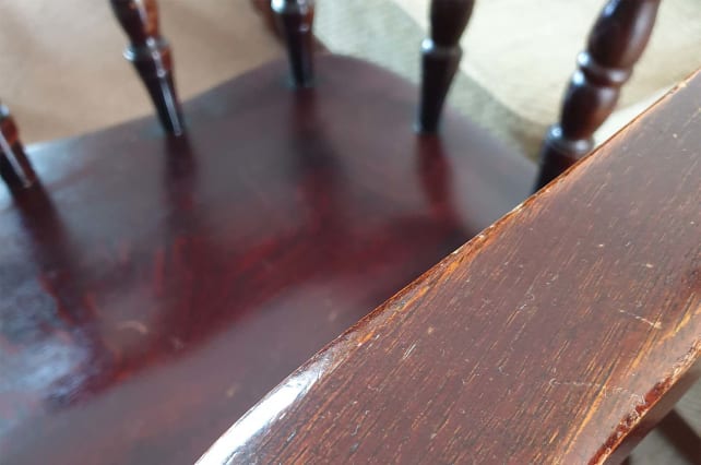 A close up of a wooden chair with signs of wear
