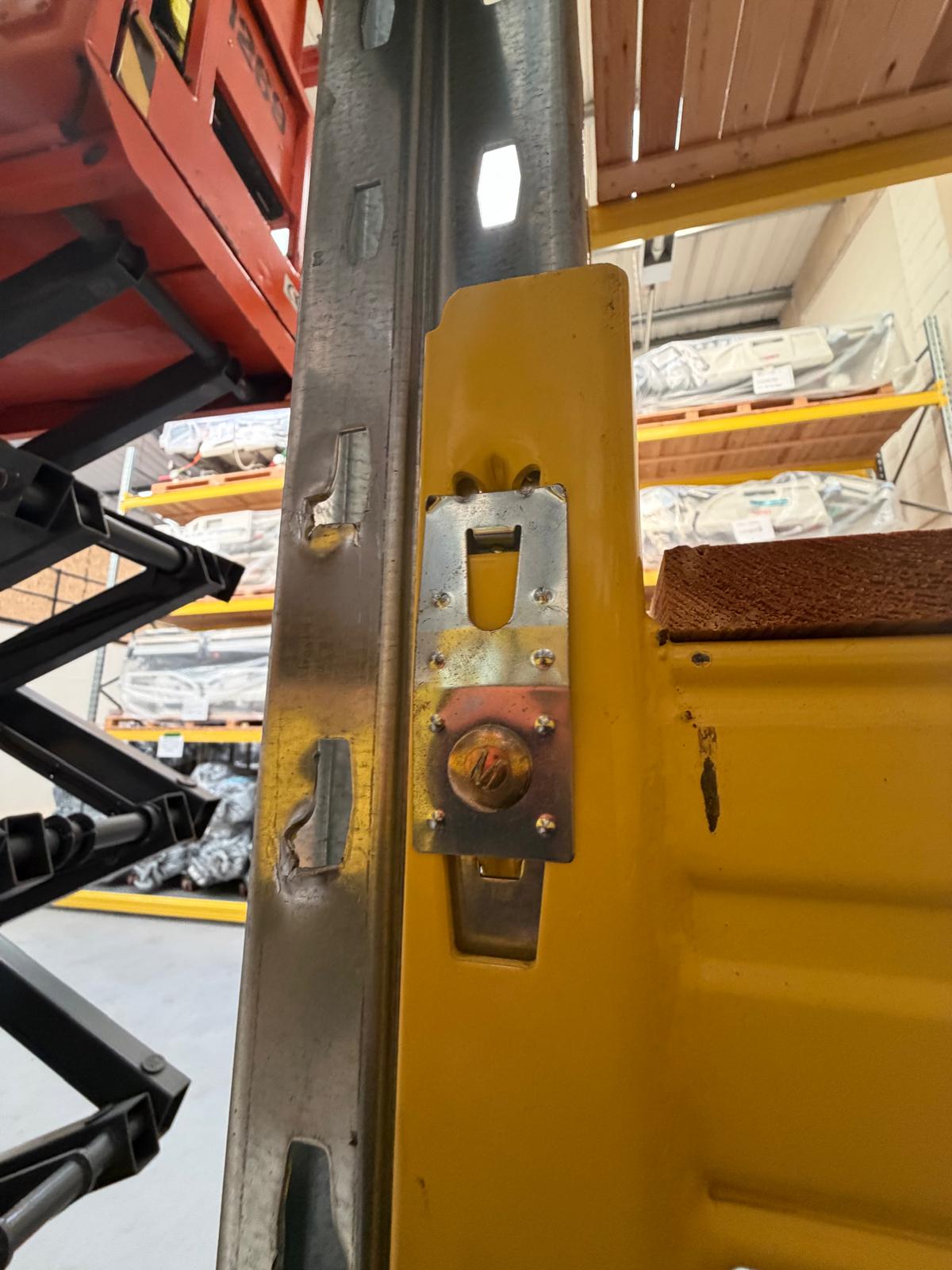 Close-up of a damaged yellow pallet racking upright showing distortion identified during emergency diagnosis