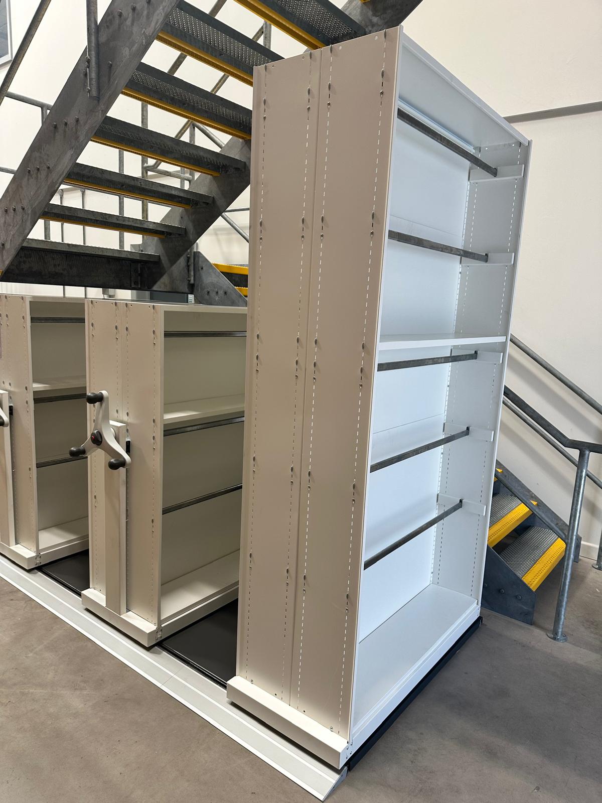 Mobile shelving carriage rail installation beneath a staircase