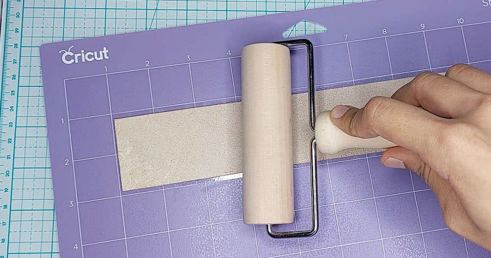 Step 5: Apply pressure using the brayer Step 5: I apply pressure to the leather using the brayer.