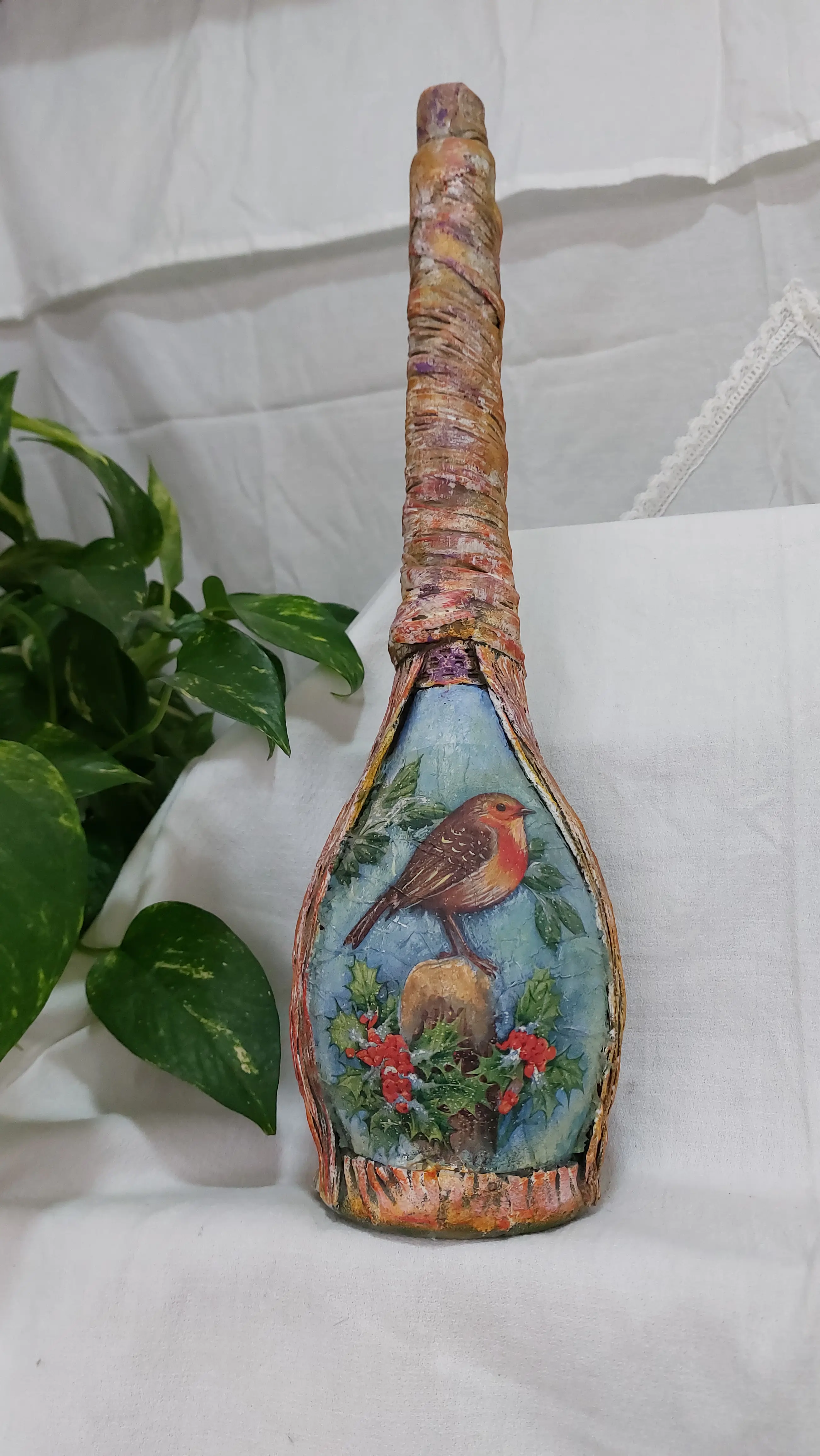 Botellón reciclado, decorada con técnica de decoupage de un pájaro sobre una rama con flores y relieve texturizado en el cuello (con tela).