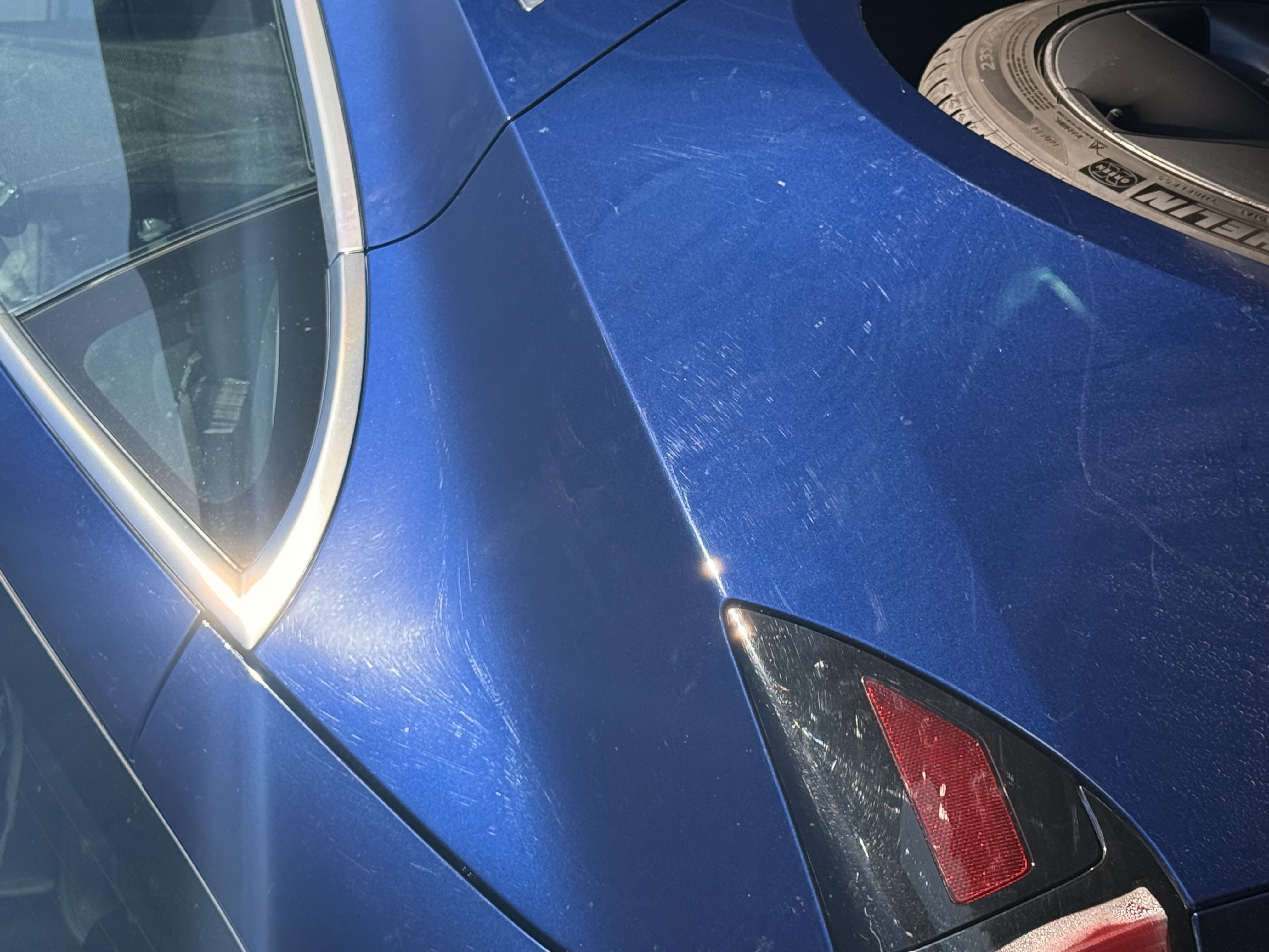 Tesla paint damage after 30000 miles showing road wear and rock chips