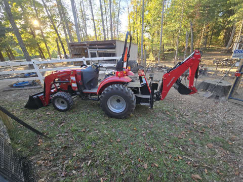 Red Mahindra tractor with front loader and backhoe on Together Built Farm