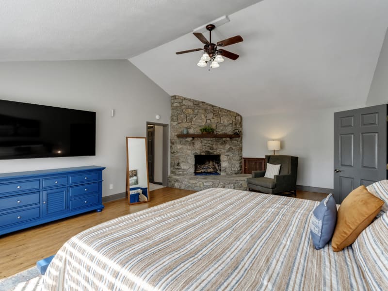 Blue Door Suite bedroom with stone fireplace and TV