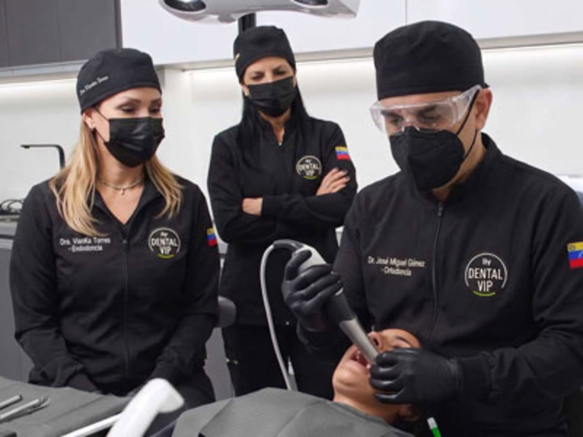 Especialista de DENTAL VIP saludando a paciente con asistente clínica en uniforme