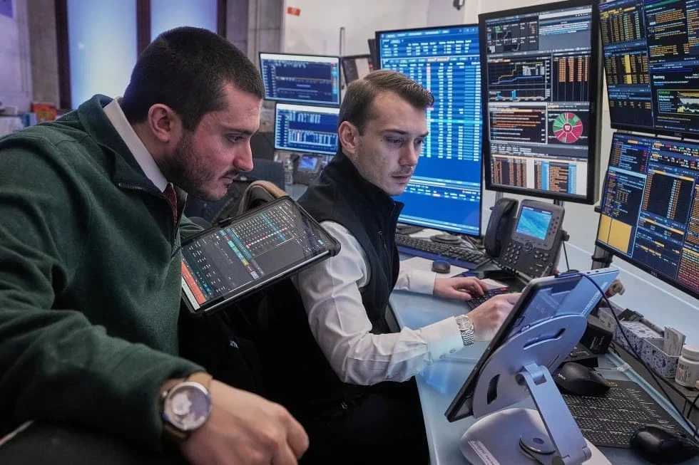 Stock market financial traders monitoring terminals and stock price graphs on Wall Street