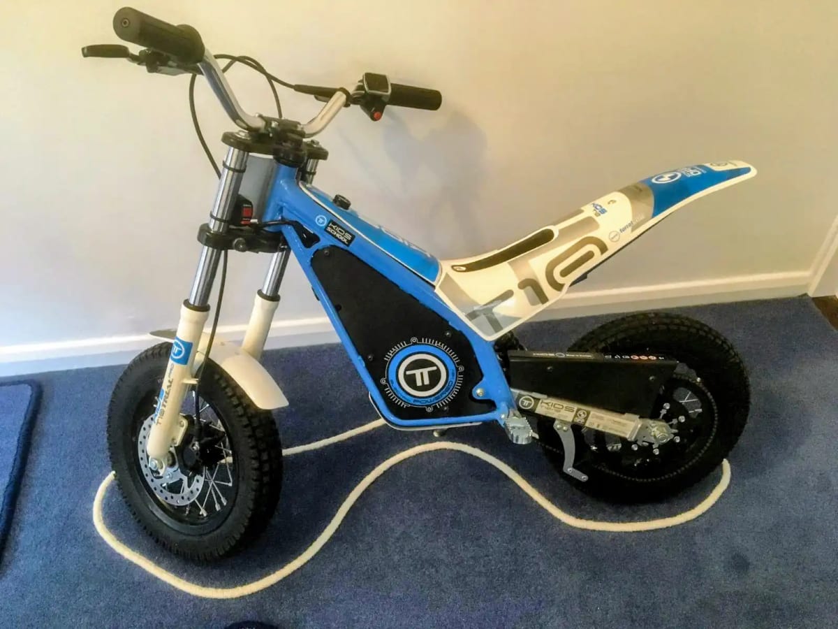 Blue and white electric motorbike on a custom whipped carpet mat