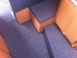 Custom-fitted, grey whipped carpets installed on multiple levels inside a boat cabin.