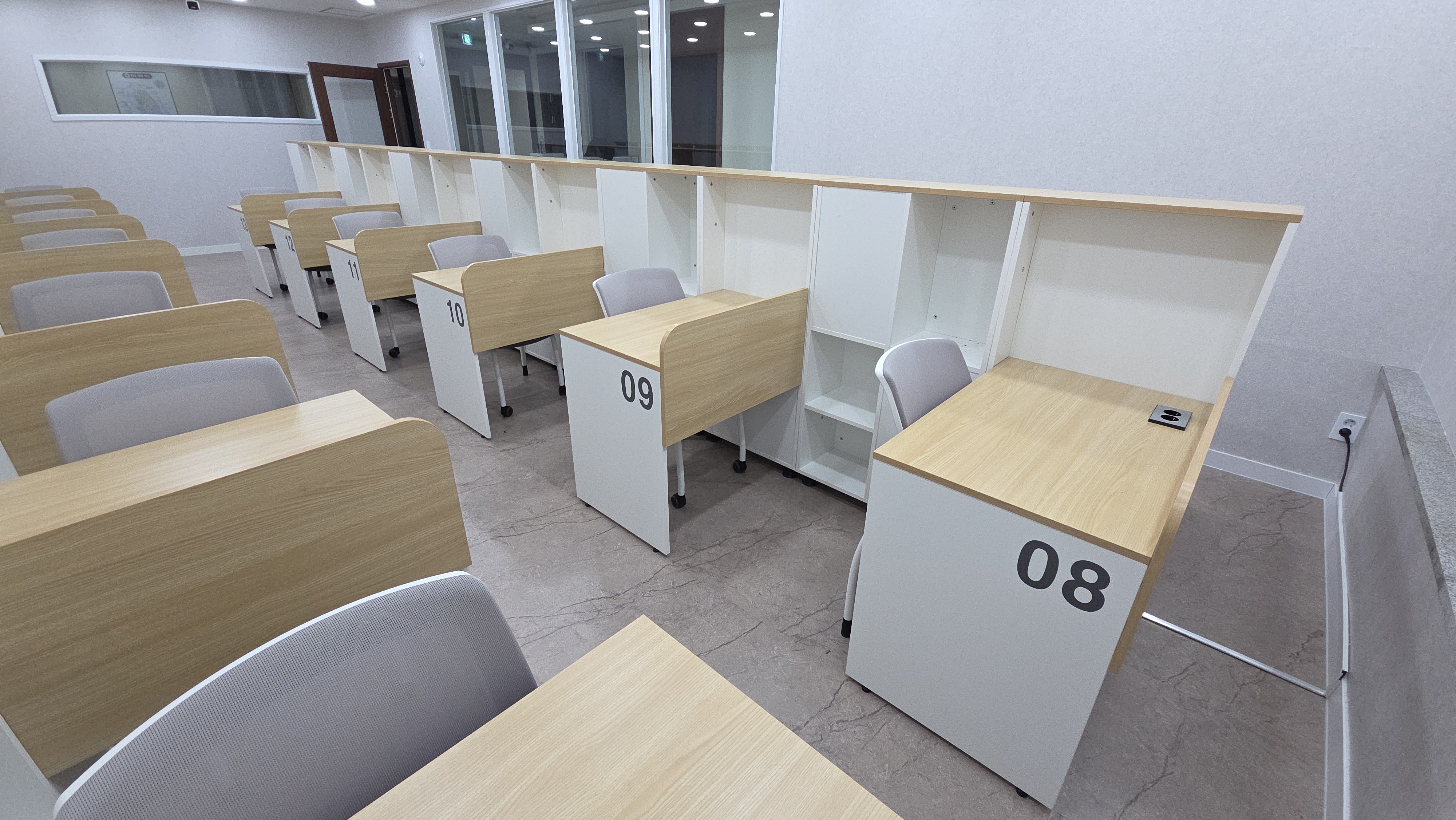 모번 책상 상판과 흰색 수납장이 보이는 좌석 