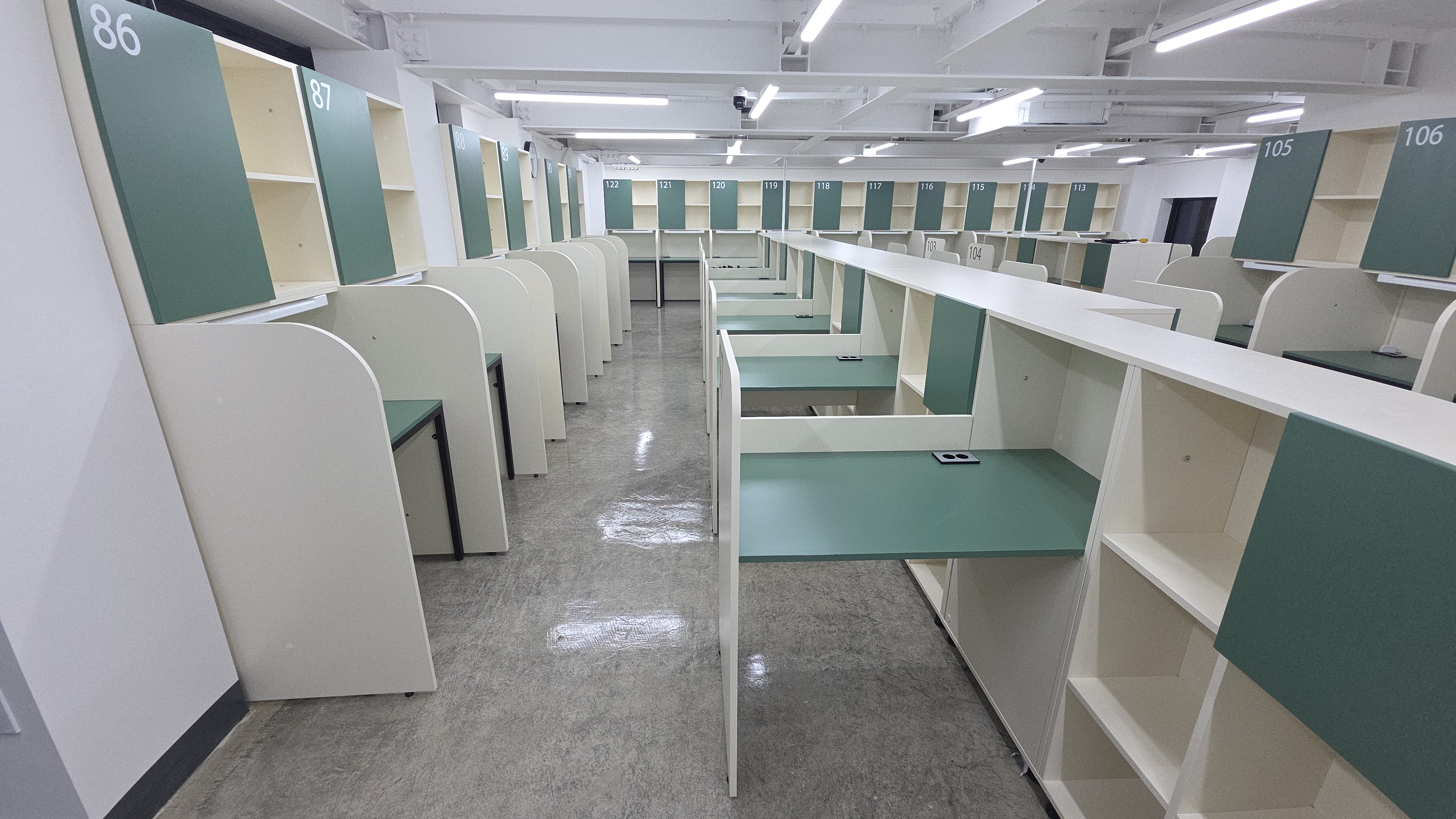 통로를 따라 마주 보는 벽면 좌석과 중앙의 올데이B 수납형 책상