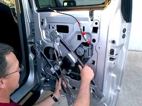 A technician carefully removing the car door panel to access the power window mechanism for repair. This step is crucial for diagnosing and fixing issues with the vehicle's power windows