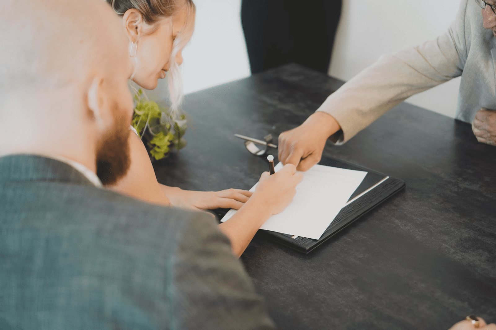 A man and women signing paperwork for their auto glass repair warranty