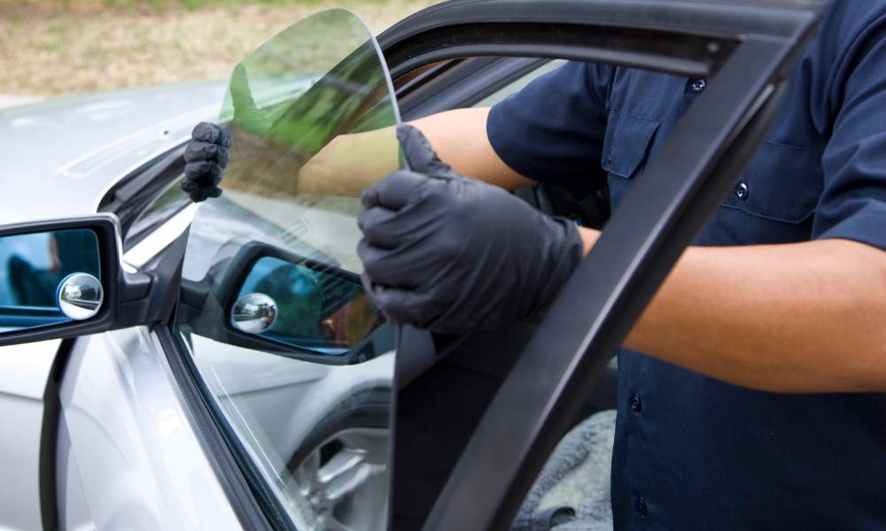 A technician installing a new side window on a vehicle, ensuring a precise fit for optimal clarity and safety.