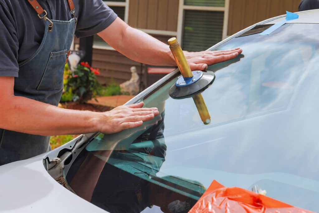 Technician replaces windshield in residential area during works day hours